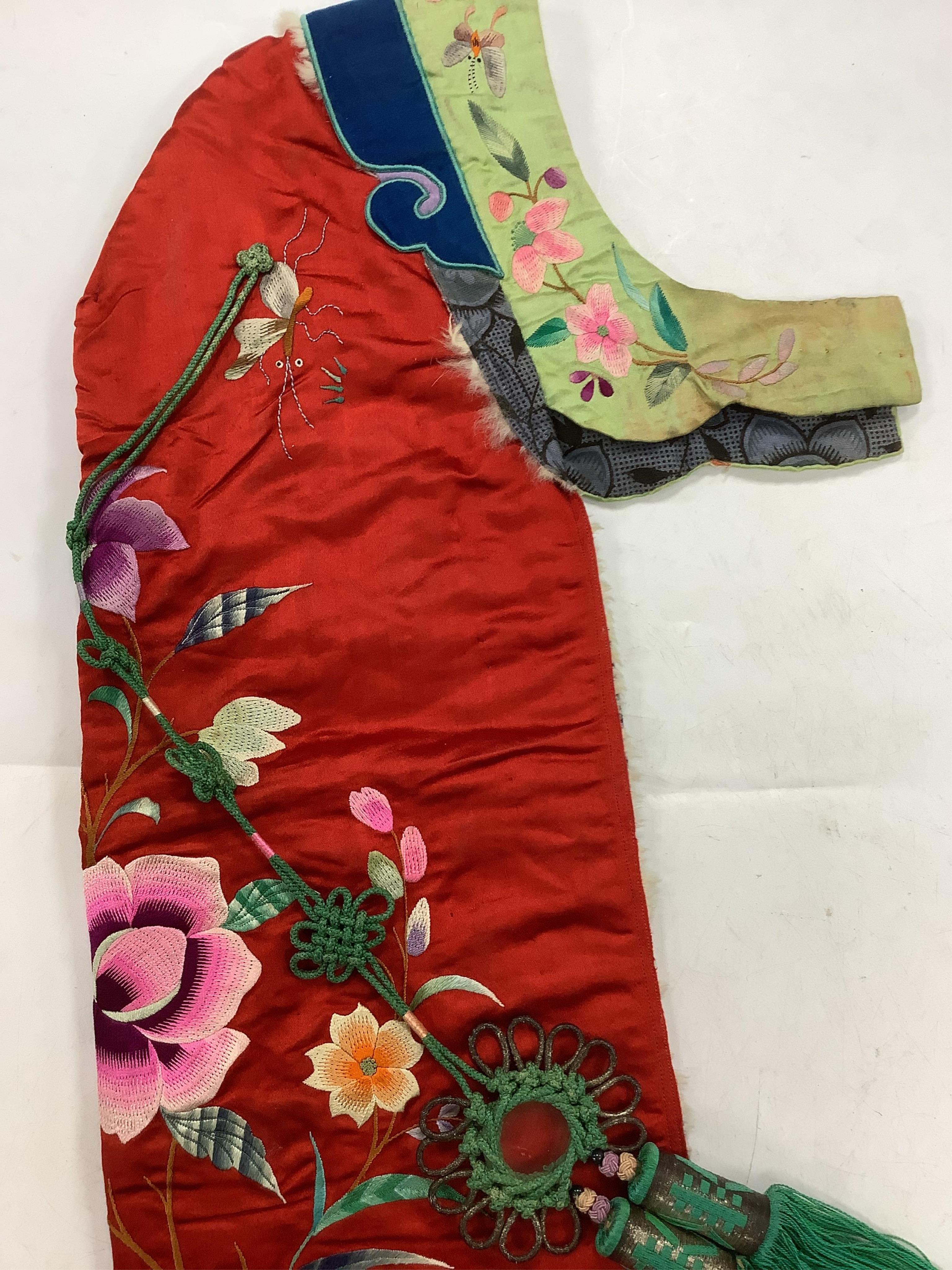 A 20th century possibly Miao, child’s multi coloured silk embroidered and padded winter hood, with fur trim and ornate tasselled decoration, 54cm long. Condition - the light green silk edge has worn and has lightly disco